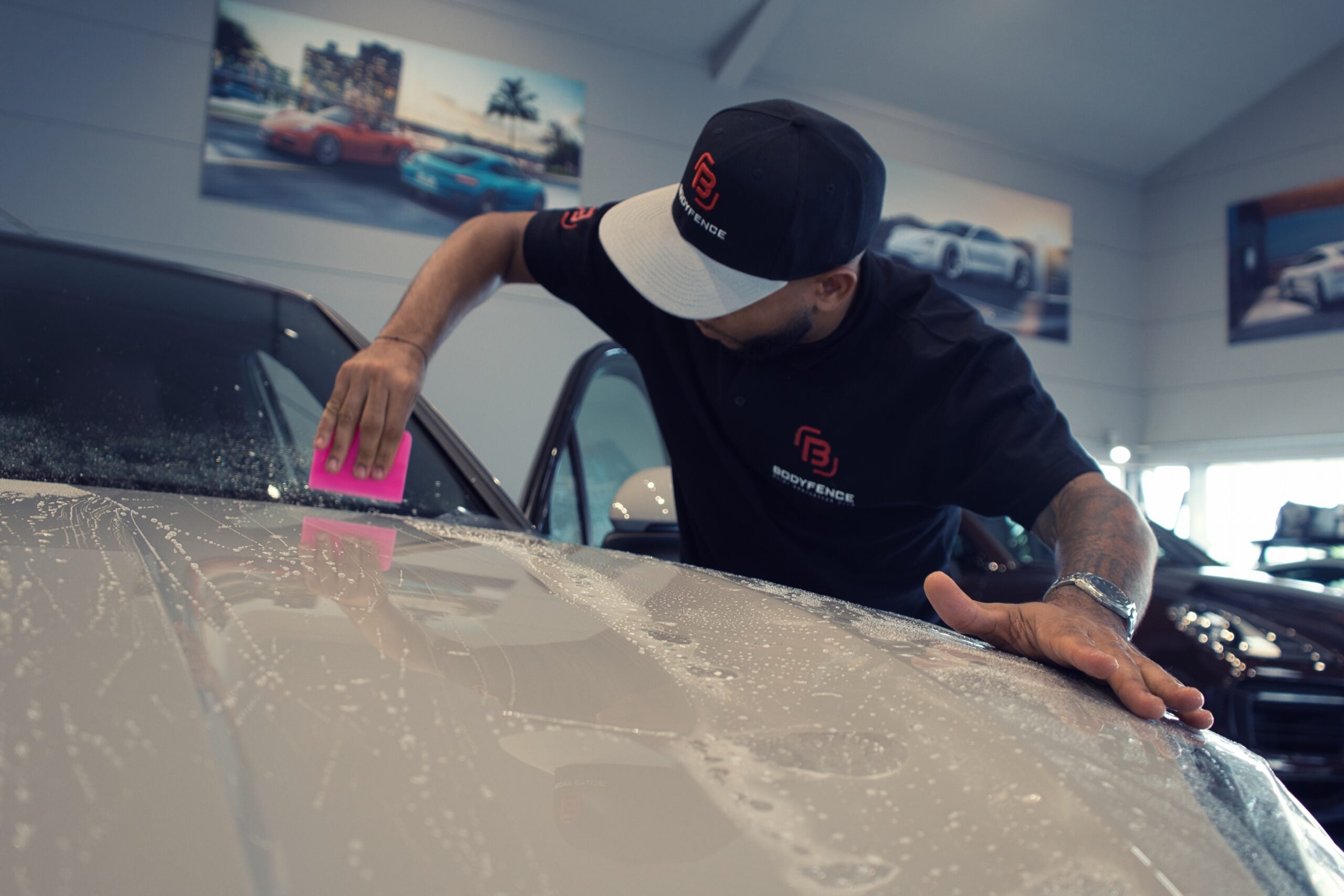 HEXIS trainer applying adhesive film to a vehicle window